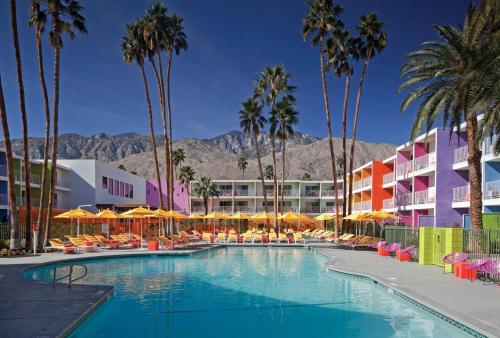 棕榈泉棕榈泉瑟括洛酒店的一座拥有棕榈树和建筑的游泳池的酒店