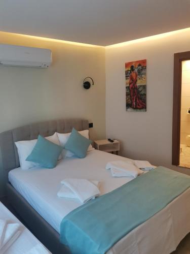 塞费里希萨尔SIĞACIK SEN KONUK EVİ的一间卧室配有一张带蓝色枕头的大床