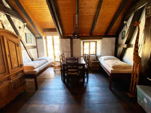 WachauFerienhaus NAMIBIA-LODGE im Rittergut Leppersdorf bei Dresden的一间设有两张床和一张桌子及椅子的房间