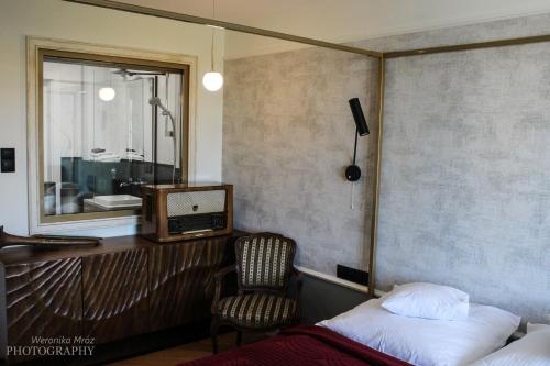 比亚韦斯托克D Apartments "Z wizytą u Branickich"的一间卧室配有一张床、一台电视和一把椅子