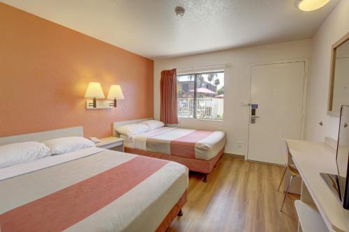 科罗娜科罗娜6号汽车旅馆的酒店客房设有两张床和窗户。