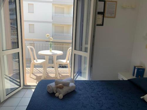 卡托利卡HOTEL LA PERGOLA的一只泰迪熊躺在卧室的床上