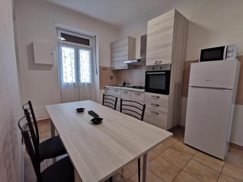 都灵HappyHome, Belissimo appartamento in Torino的厨房配有桌子和白色冰箱。