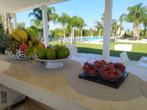 加利波利Tenuta Espada Luxury Residence的桌上的两碗水果和游泳池