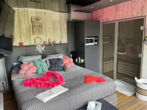 图尔奈La chambre du puits avec 2 jacuzzis , sauna et Hammam privatif的一间卧室配有带粉色和绿色枕头的床