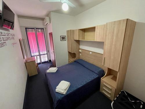 卡斯特罗卡罗泰尔梅Hotel Villa Serena的一间设有蓝色床和木制橱柜的小卧室