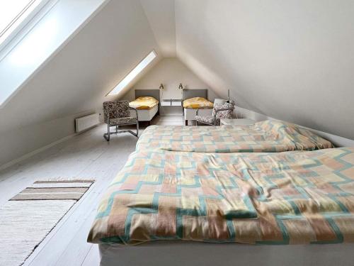 英斯约Holiday home YNGSJÖ, SVERIGE II的阁楼卧室配有两张床和一张桌子及椅子