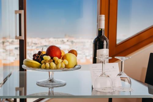 布拉格Wenceslas Square Hotel - Czech Leading Hotels的桌上的水果盘和一瓶葡萄酒
