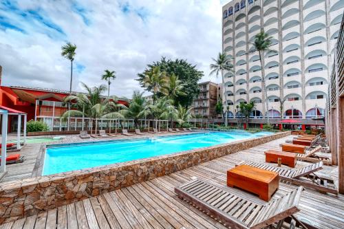 杜阿拉AKWA PALACE Douala的一座带躺椅的酒店游泳池以及一座建筑