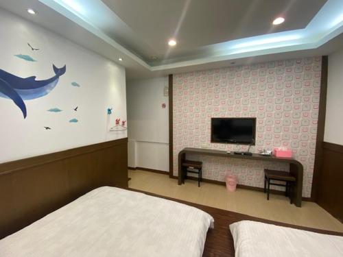 小琉球岛尹居 包棟民宿的一间卧室设有两张床,墙上配有电视。