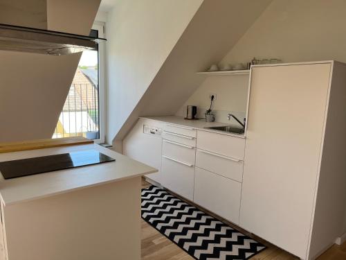 卢布尔雅那Apartment Malina - free private parking的一间小厨房,配有白色的橱柜和窗户