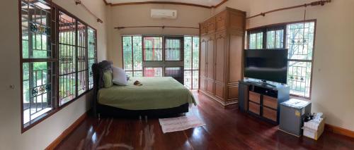 拉差汶里Keith Ratchaburi的客房设有1张床、1台电视和窗户。