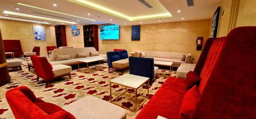 麦加Al Ebaa Hotel的带沙发、椅子和电视的等候室