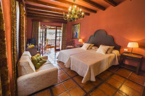 伊科德洛斯维诺斯圣马科斯标志酒店的一间卧室配有一张大床和一张沙发