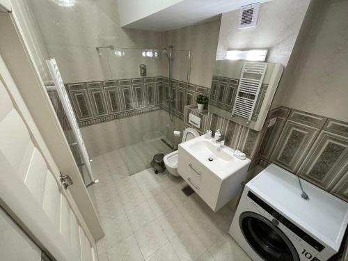 马马亚Mamaia Beach LuxyMar 3 Apartment的带淋浴、盥洗盆和洗衣机的浴室
