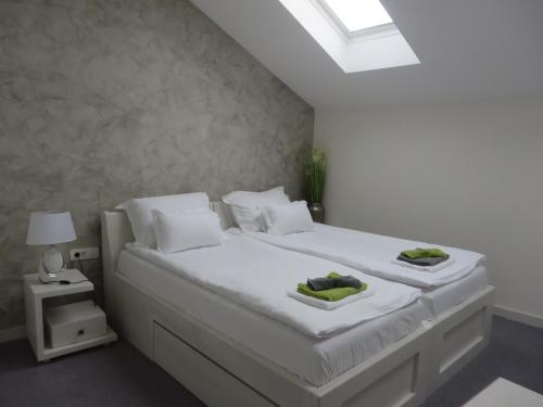 贝尔格莱德Villa Marija M L的卧室配有白色的床和2条毛巾