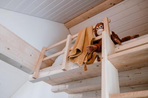 阿尔邦Hotel Müllers Self-Check-In的一只玩具猴子坐在双层床上