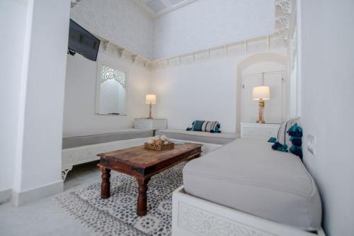 莫纳斯提尔Dar Benti的白色卧室配有床和桌子