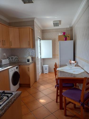 米尔芳提斯城T2,Casa Sol e Mar 50464/AL的厨房配有桌子和白色冰箱。