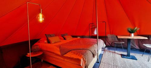 龙塞Fiertelmeers Boutique Glamping的红色卧室,帐篷内提供一张床