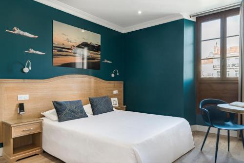 土伦The Originals Boutique, Grand Hôtel de la Gare, Toulon的一间卧室设有一张床和蓝色的墙壁