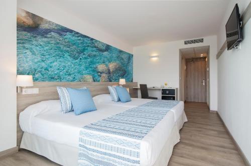滨海罗克塔斯Hotel Roquetas El Palmeral by Pierre & Vacances的卧室配有带蓝色枕头的大型白色床