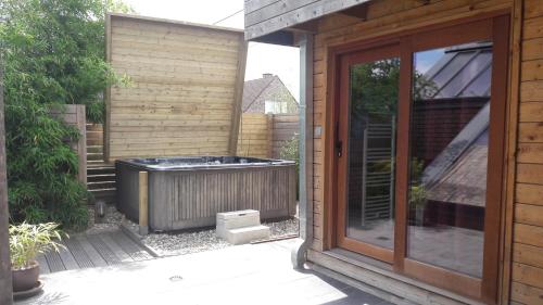 图尔奈B&B Aquavert & Wellness的房屋外的热水浴池,带滑动玻璃门