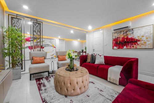 拉各斯Sapphire Heights Apartment的客厅配有红色的沙发和桌子