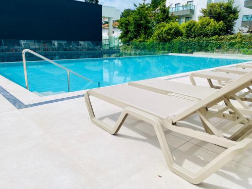 桑亨霍Hotel Silgar 92的游泳池旁的白色躺椅