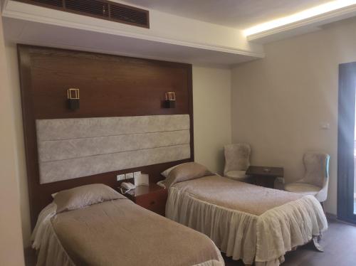 开罗贝鲁特开罗酒店的酒店客房,配有两张床和两把椅子