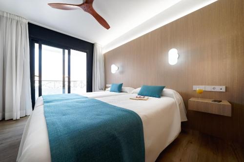 美洲海滩Hotel Parque La Paz的一间卧室设有两张床和大窗户