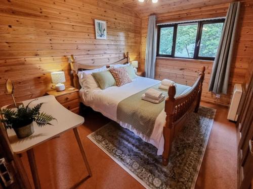 LlanfachrethWnion Wood Lodge with log burner & sauna in Snowdonia的小木屋内一间卧室,配有一张床
