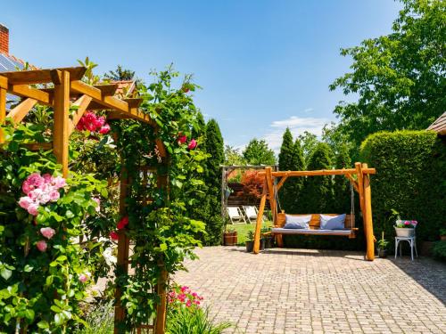 鲍洛通塞迈什Apartment Bocskai by Interhome的花园设有凉亭和玫瑰长凳