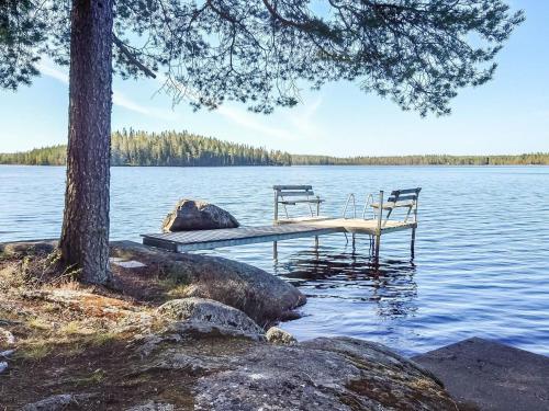 SoiniHoliday Home Mäntylä by Interhome的两把椅子坐在湖面上的码头上