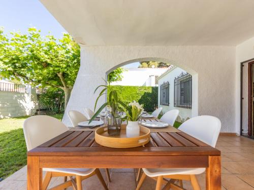 坎布里尔斯Villa Villa Valencia by Interhome的一间带木桌和白色椅子的用餐室