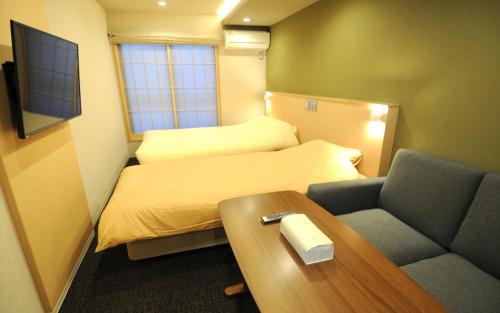 京都HIZ HOTEL Kyoto Nijo Castle - Vacation STAY 12537v的小房间设有床、桌子和沙发