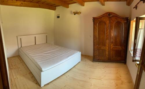 鲍洛托奈代里奇Balaton home with a majestic view的一间卧室配有一张床和一个木制橱柜