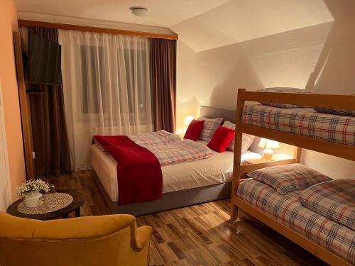 弗拉西克Hotel Central Vlašić的一间带两张双层床和一张沙发的卧室