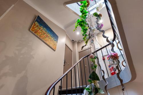 戛纳Hotel l'Hotera的墙上挂着一幅画和鲜花的楼梯