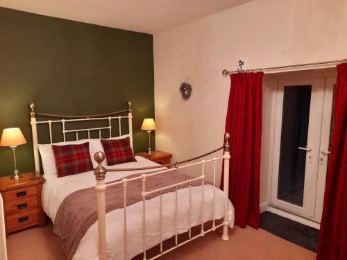 惠特比Underhill Holidays - Underhill Holiday Cottage的一间卧室配有红色窗帘的床