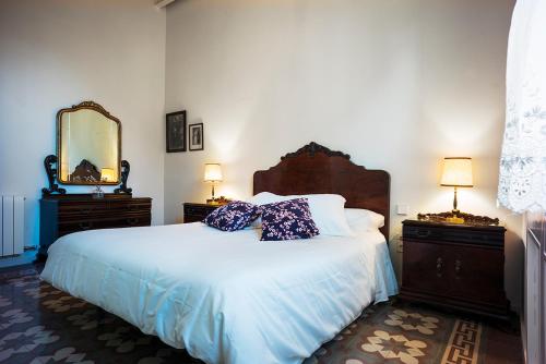 卡德德乌Cal Peó ByBCardedeu的一间卧室配有一张带两个梳妆台和镜子的床