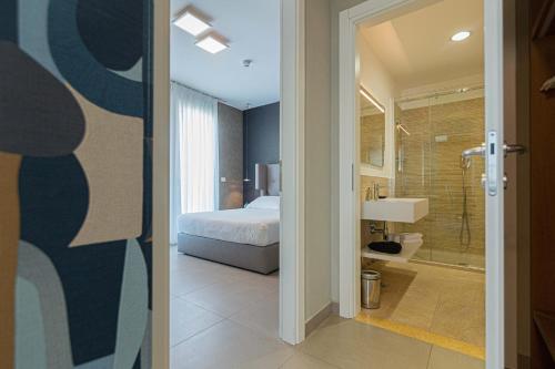 索托马里纳Mosella Suite Hotel的一间卧室配有一张床,浴室设有淋浴。