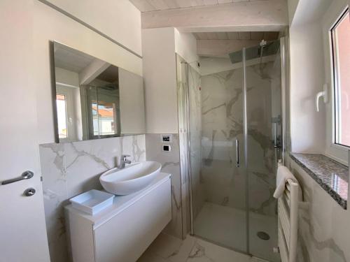 科利科Royal apt Colico Lake Como的白色的浴室设有水槽和淋浴。