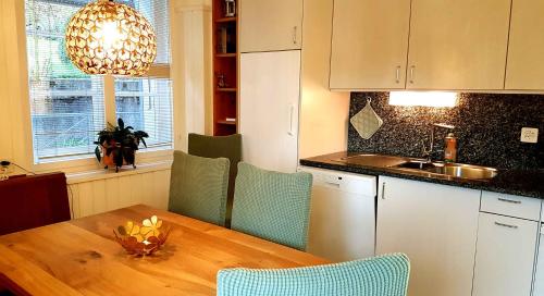 波斯基亚沃Appartamento incantevole: CASA SAN PIERU的厨房配有木桌、椅子和水槽