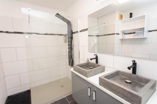 皮特尔角城BOULEVARD LEGITIMUS的浴室配有2个水槽和白色瓷砖墙壁。