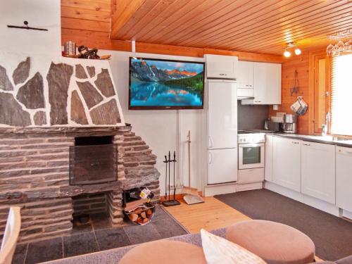 尼尔西艾Holiday Home Lomasyväri 810 by Interhome的厨房设有石制壁炉和平面电视。