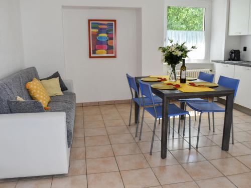 MagadinoApartment Le Bolle by Interhome的一间带桌子和蓝色椅子的用餐室