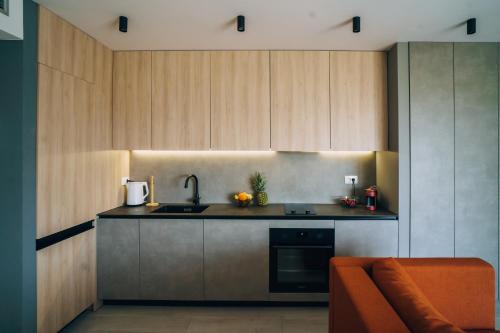 波尔Solis Apartments Bol的厨房配有木制橱柜、水槽和沙发。
