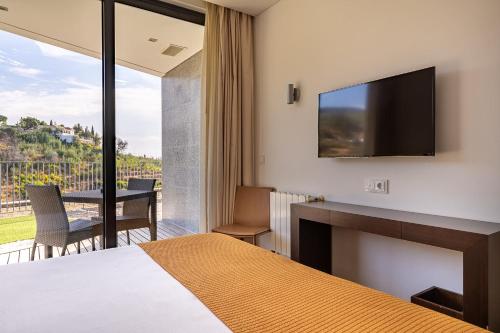 蒙希克Monchique Resort & Spa的配有一张床和一台平面电视的酒店客房