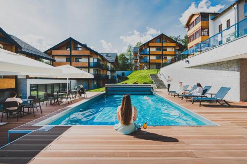 卡尔帕奇Tremonti Hotel Karpacz的坐在酒店游泳池里的女人